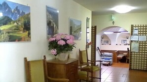 Un salon avec des meubles en bois, une plante en pot et une vue sur une autre pièce.