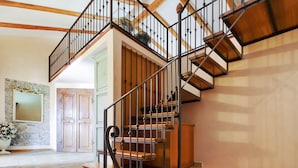 A grand staircase with a wooden finish and metal railings, leading to an upper level. - Corso Umberto (Taormina)