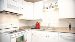 A modern kitchen with white cabinets, a built-in microwave, a coffee maker, and a dishwasher. - Medical & Work Stay · Quiet · Fenced Pet · Friendly (Durham)