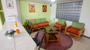 A living room with a sofa set, a coffee table, a microwave, and a potted plant. - Quiet, spacious and quiet apartment in Quito  (Quito)