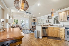 A spacious kitchen with wooden cabinets, a dishwasher, and a large island. - Sunset View at CrossTimbers Marina (Sperry)