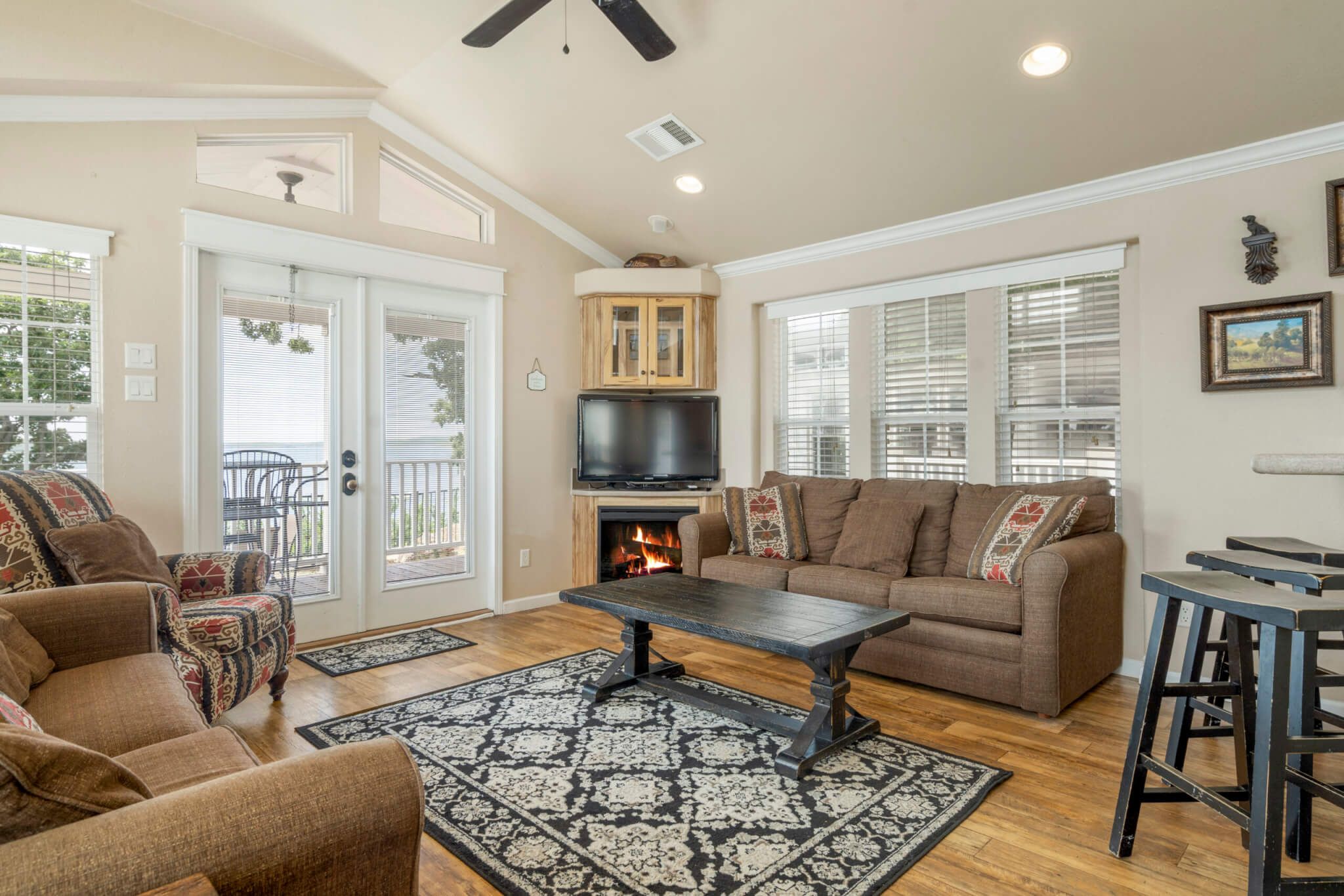 A spacious living room with a fireplace, comfortable seating, and a television.