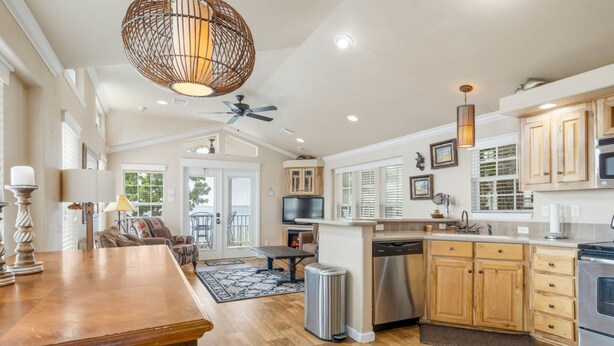 A spacious kitchen with wooden cabinets, a dishwasher, and a large island. - Sunset View at CrossTimbers Marina (Sperry)