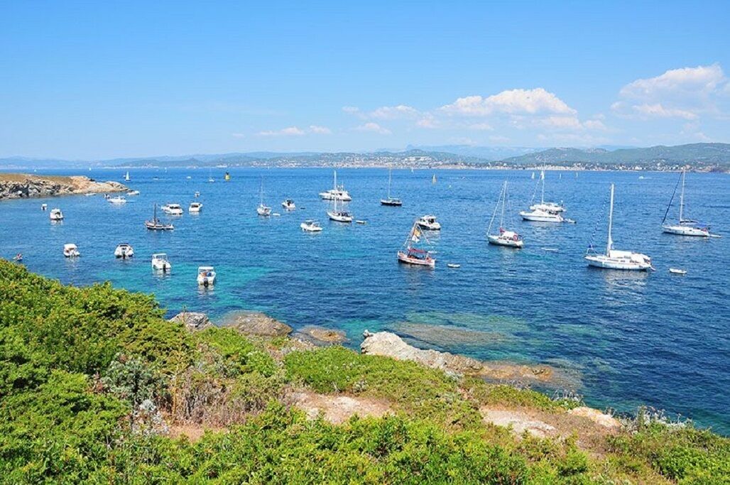 A coastal marina with various boats and yachts anchored in calm waters.
