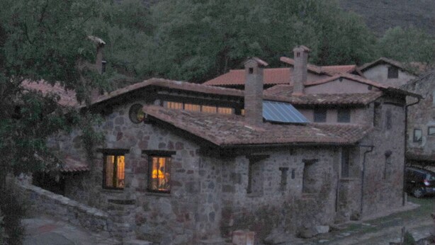 Un bâtiment en pierre doté d’un toit en pente et de plusieurs cheminées.