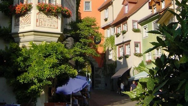 A historic building with a clock tower, ornate facade, and flower boxes. - Mittelalterhotel-Gästehaus Rauchfang (Meersburg)