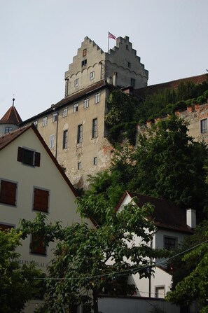 A historic building with a castle-like structure on top, surrounded by residential buildings. - Mittelalterhotel-Gästehaus Rauchfang (Meersburg)