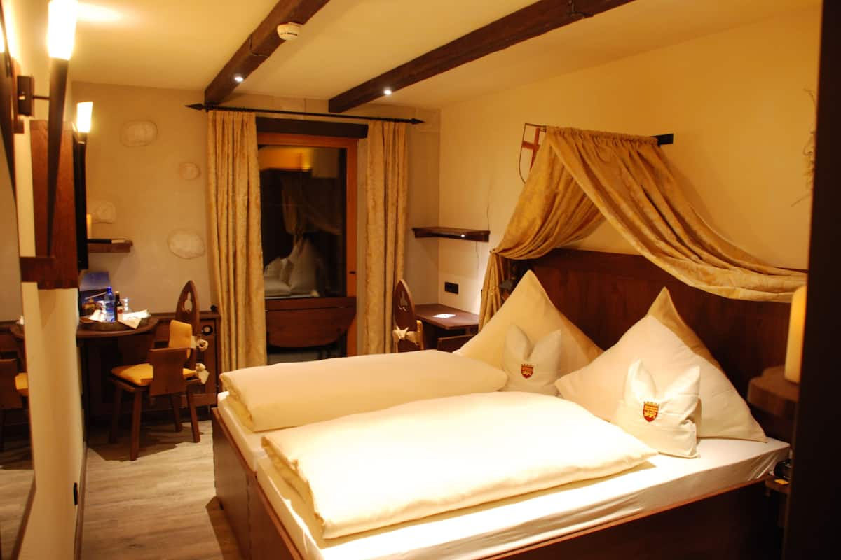 A hotel room with a bed, a desk, and a chair.