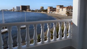 Un balcón con vista a la playa y edificios.
