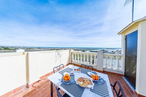 A terrace with a table set for breakfast, overlooking a coastal view. - Nice chalet house in Perellonet (Valencia)