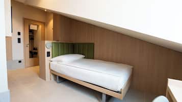 A modern bedroom with a bed, a green headboard, and a wooden wall.