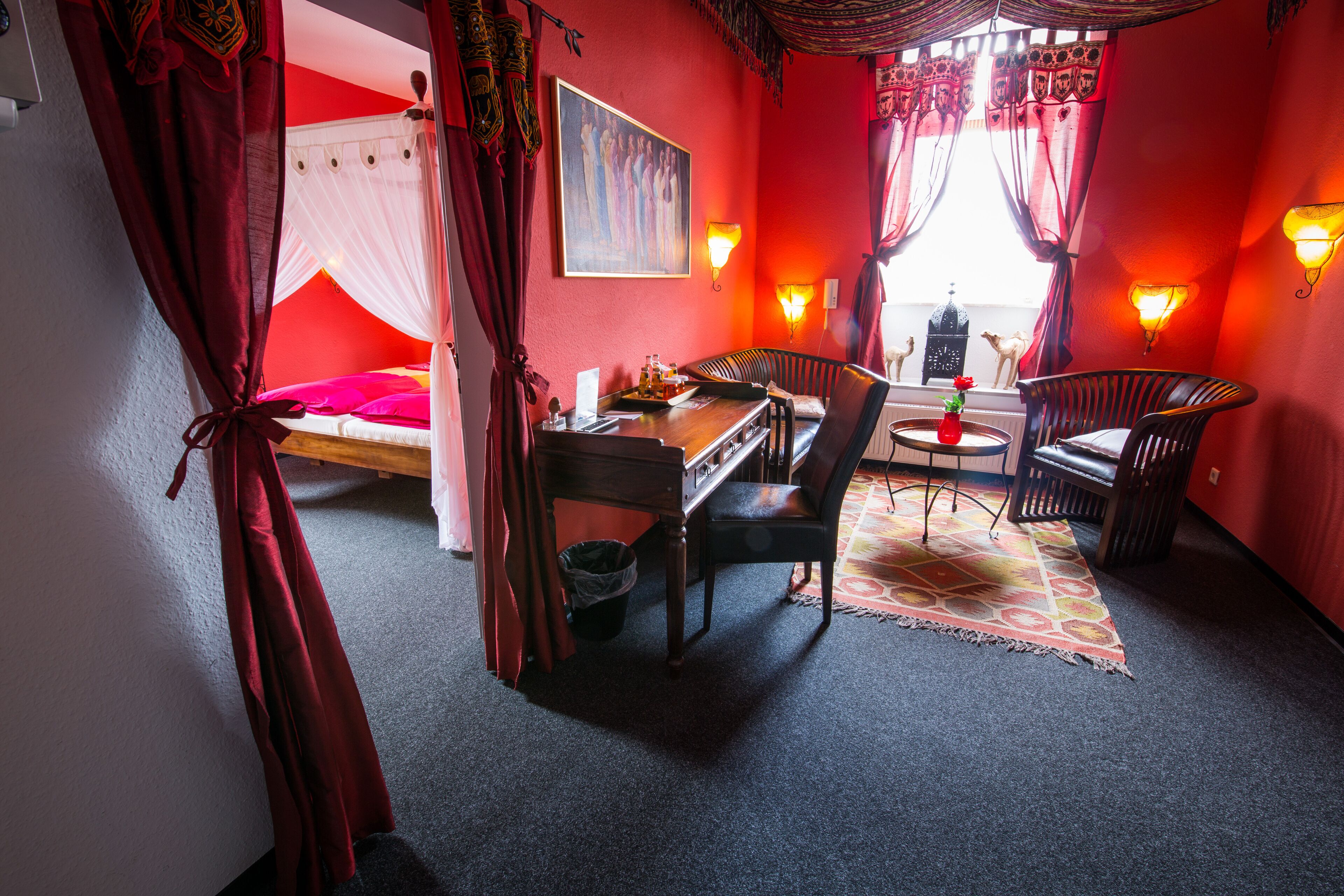 Ein Zimmer mit einem Bett, einem Schreibtisch, zwei Stühlen, einem Teppich und einem Bild an der Wand.