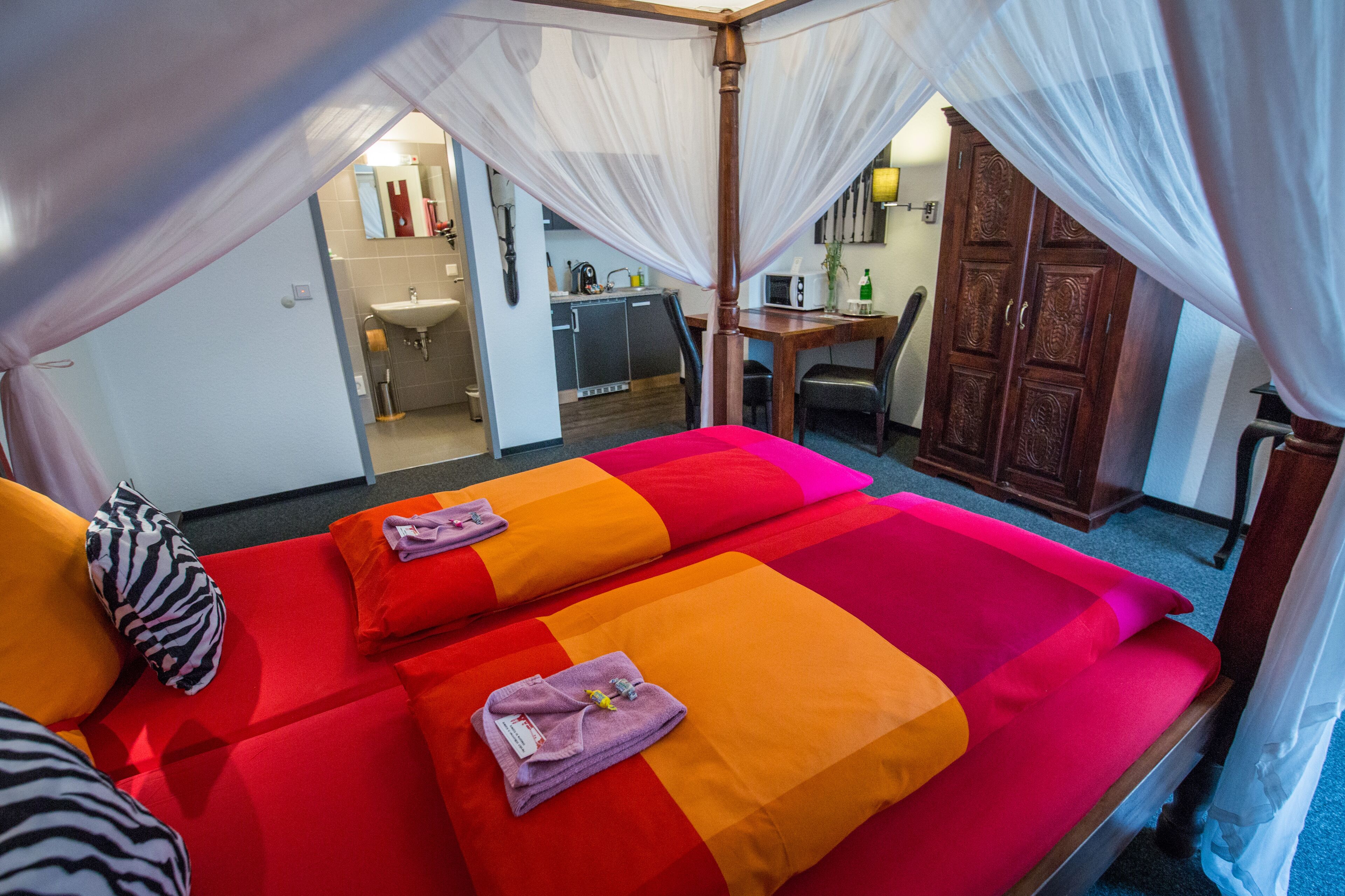 A room with two beds, a desk, and a wardrobe.