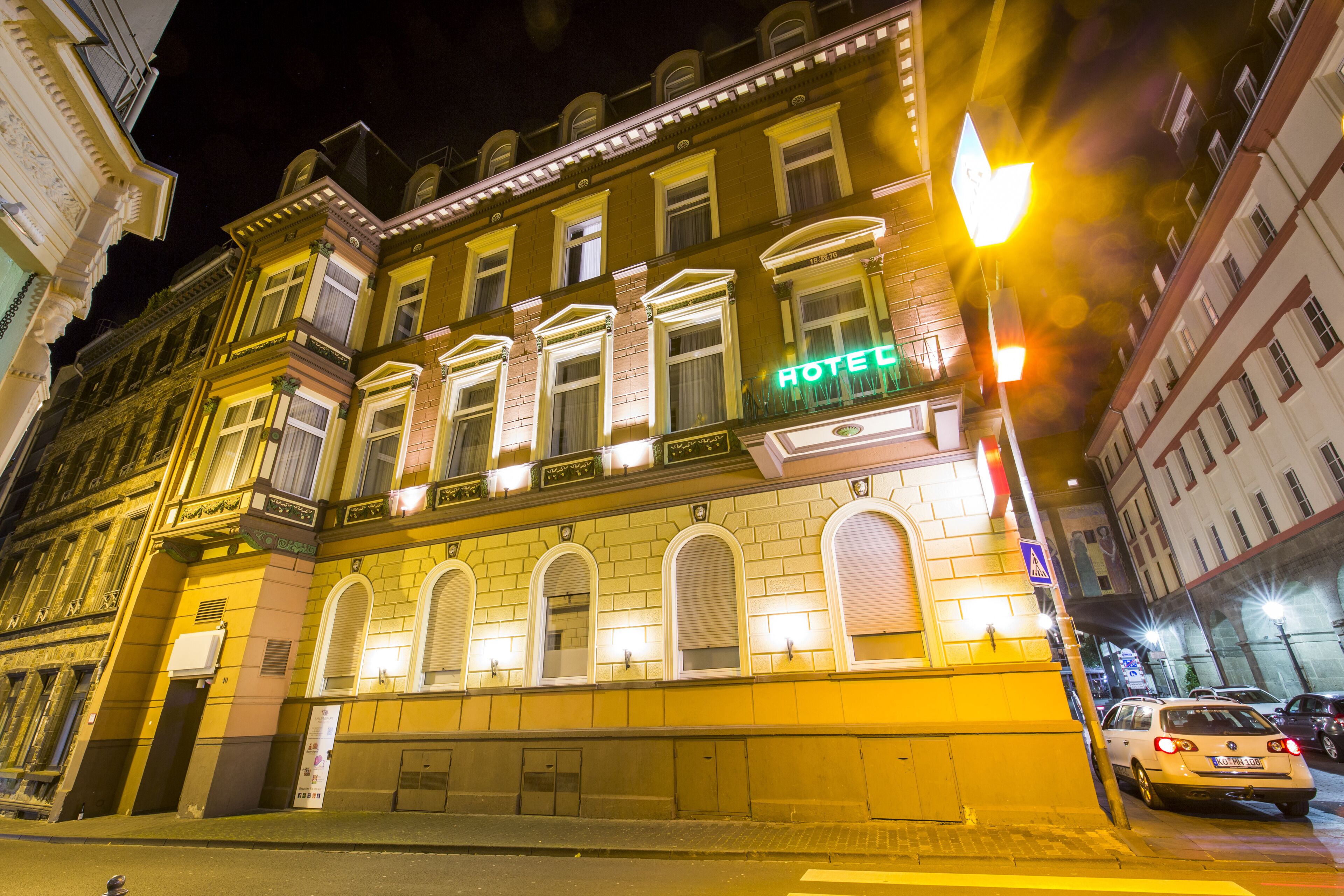 A hotel with a classic facade, multiple windows, and a prominent 'HOTEL' sign.