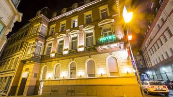 A hotel with a classic facade, multiple windows, and a prominent 'HOTEL' sign.