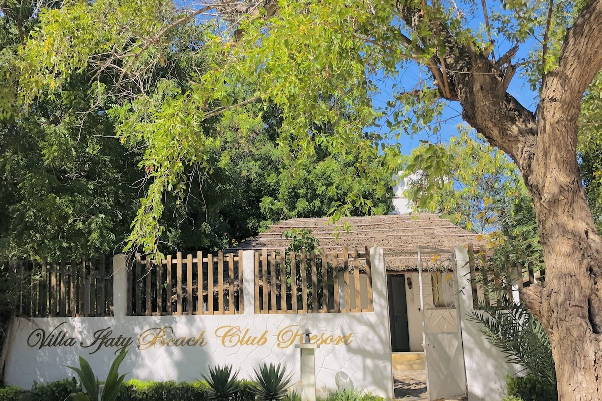 Entrada com portão para o Villa Fatty Beach Club Resort, com caminho bem definido até o portão.