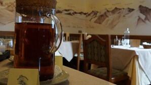 Uma mesa com uma chávena de vidro de chá com o rótulo 'Mela Verde' e um menu.