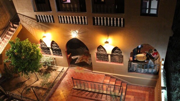 Un patio con escaleras, arcos y un pequeño jardín.