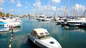 Un port de plaisance où sont amarrés de nombreux bateaux, avec une eau calme et un ciel dégagé.