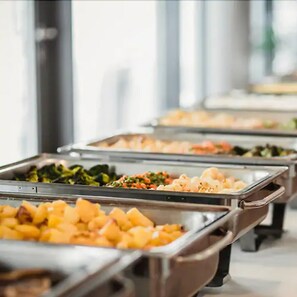 Un bufé con diversas opciones de comida, incluyendo verduras y frutas.