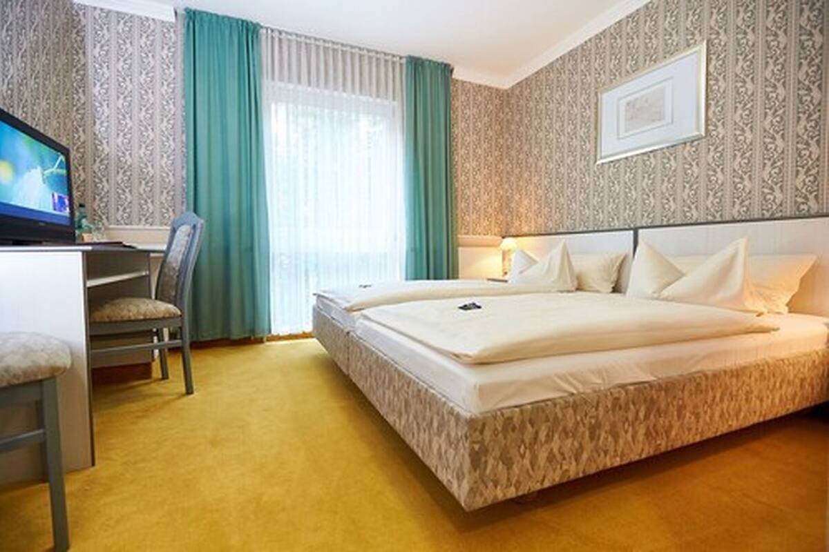 Une chambre d’hôtel équipée d’un lit, d’un bureau, d’une chaise et d’un téléviseur.