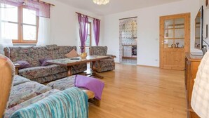 Una sala de estar con un sofá, una mesa de centro y un aparador de madera.