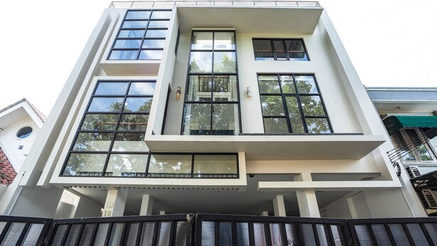 A modern multi-story building with large windows and a flat roof.