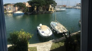Ein Yachthafen mit vertäuten Booten, umgeben von Gebäuden und Bäumen.