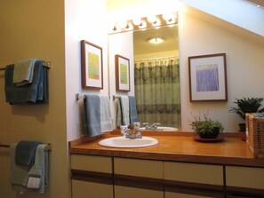 A bathroom with a wooden vanity, a sink, a mirror, and framed artwork on the wall. - Ithaca Urban Retreat II / Mid-term rental 30 days + only (Ithaca)