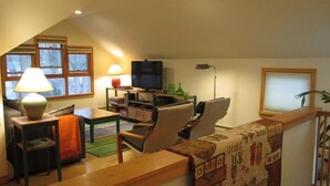 A cozy living room with a television, a lamp, a sofa, and a coffee table.