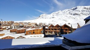 Eine verschneite Stadt mit Holzhäusern, darunter ein Skigebiet.