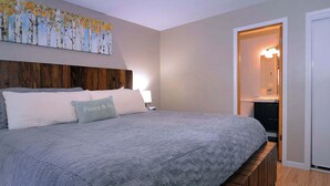 A bedroom with a large bed, a headboard, a bedside table, and a nightstand. - Aspen at Outrun, Great renovated 3 BR, Hot tub (Crested Butte)