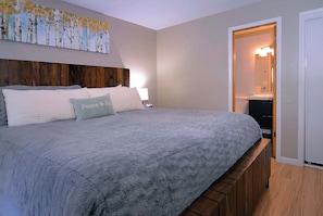 A bedroom with a large bed, a headboard, a bedside table, and a nightstand. - Aspen at Outrun, Great renovated 3 BR, Hot tub (Crested Butte)