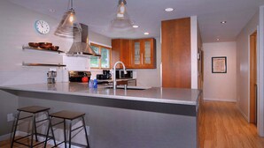 A modern kitchen with a central island, stainless steel appliances, and wooden cabinets. - Aspen at Outrun, Great renovated 3 BR, Hot tub (Crested Butte)