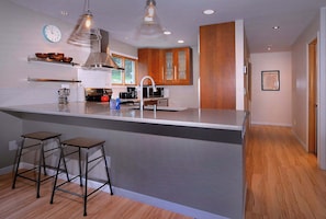 A modern kitchen with a central island, stainless steel appliances, and wooden cabinets. - Aspen at Outrun, Great renovated 3 BR, Hot tub (Crested Butte)