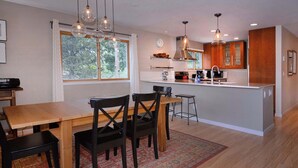 A modern kitchen with a dining area, wooden furniture, and pendant lighting. - Aspen at Outrun, Great renovated 3 BR, Hot tub (Crested Butte)