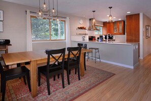 A modern kitchen with a dining area, wooden furniture, and pendant lighting. - Aspen at Outrun, Great renovated 3 BR, Hot tub (Crested Butte)