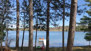 A lakeside cabin with a dock, surrounded by tall pine trees. - SUMMER fun in a cozy log lake home on the Whitefish Chain under the tall pines (Crosslake)