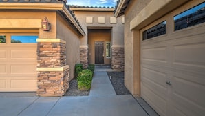 A residential house with a garage, a front door, and a pathway leading to the entrance.