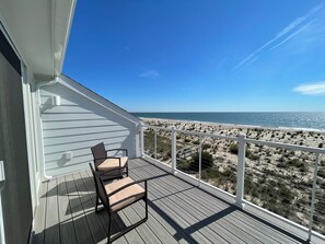 En balkon med udsigt over stranden og havet.
