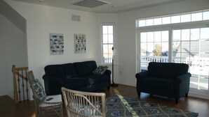 A living room with two dark-colored sofas, a patterned rug, and a wooden chair.