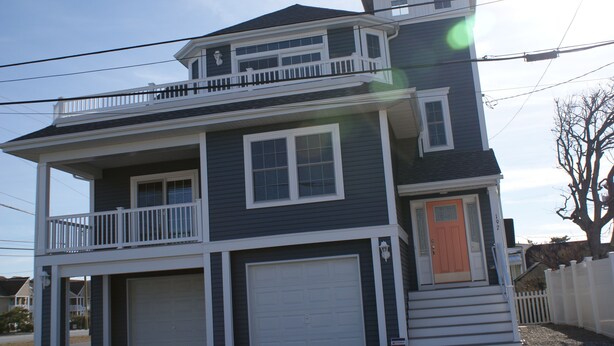A two-story house with a front porch, a garage, and a balcony.