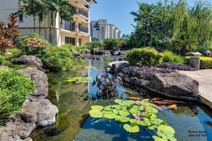 A landscaped garden with a pond, rocks, and water lilies. - Beach Villas at KoOlina Oceanviews (Kapolei)
