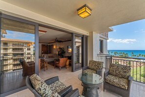 A balcony with wicker furniture, a glass table, and a view of the ocean. - Beach Villas at KoOlina Oceanviews (Kapolei)