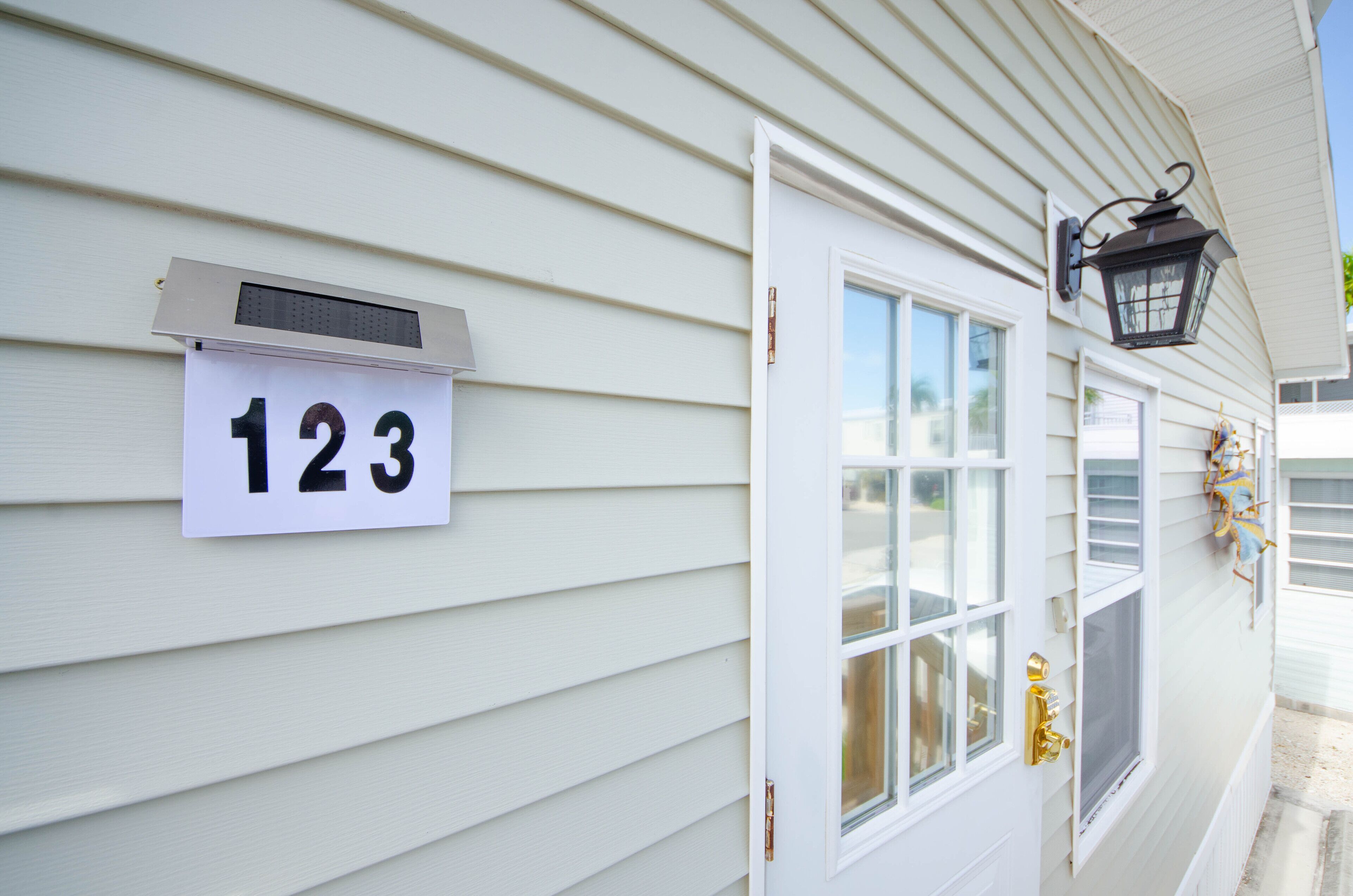 A house with a number sign '123' and a door with a window.