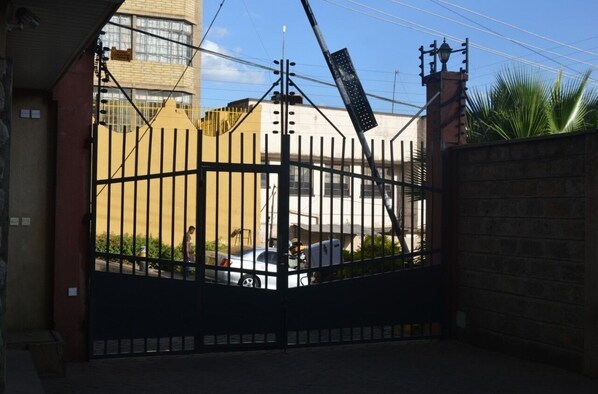 Secure entrance to a modern building with parking area and flat roof.