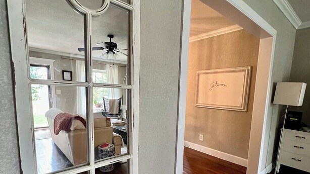 A room with a large arched window, wooden flooring, a bed, a desk, and a framed artwork on the wall. - Charming Midtown Home near Fairgrounds/TU/Downtown (Tulsa)