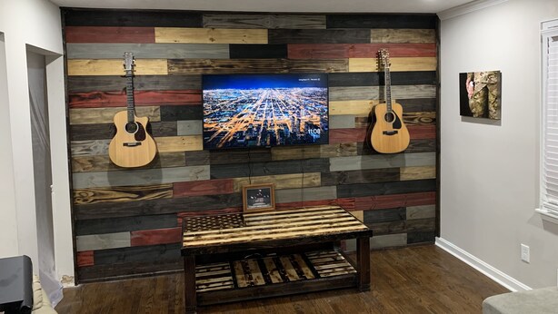 A room with a wooden wall panel, a flat-screen TV, two guitars, and a bench. - The Masters Rental! Less than half a mile from course! (Augusta)