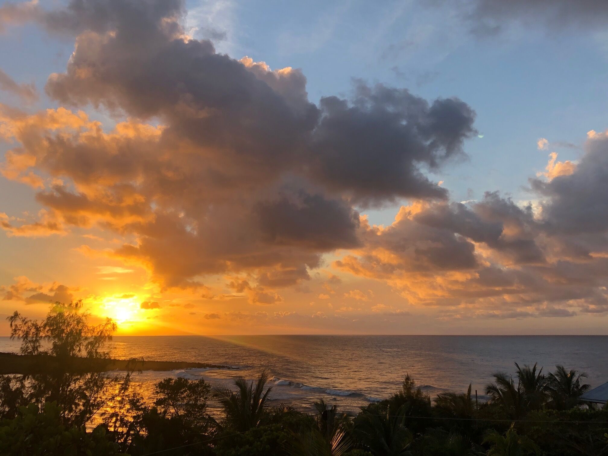 Ein Sonnenuntergang über dem Meer mit Wolken am Himmel.