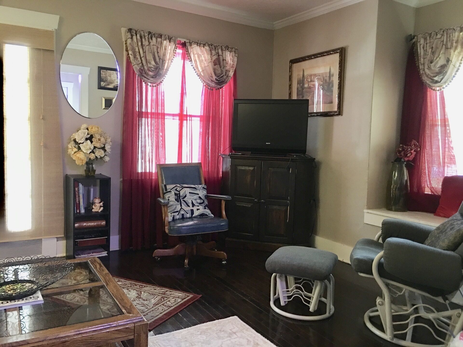 A living room with a television on a cabinet, two armchairs, a coffee table, and a rug.